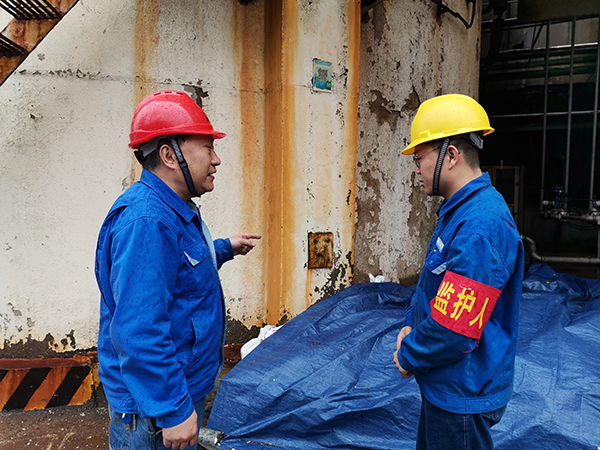 3月31日上午，在一期鍋爐舊脫硫塔底部清理現場，安全員焦路秦對監護人岳維哲的提問。.jpg