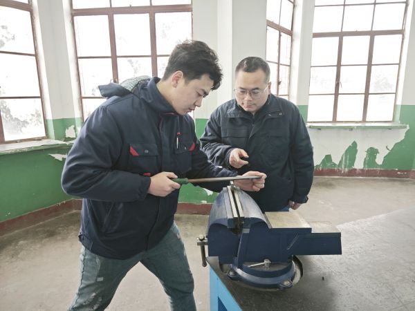 1705624316764512.jpeg 技術能手——郭峰峰正在指導青工張帆鉗工操作技能.jpg