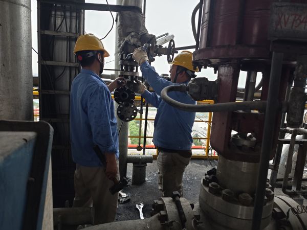 1713246575278493.jpeg 4月13日下午,大雨滂沱,計控電儀部段長左克利衣服已被飄進來的雨水打濕,他和青工王飛正在氣化樓六樓進行差壓變送器法蘭拆檢工作.jpg