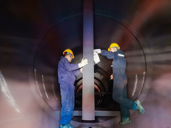 151744682004387487.jpg (圖一)4月13日上午,在52工段給水除氧器內,工藝技術員王偉正在給青工岳維哲講述除氧器內部構造.jpg